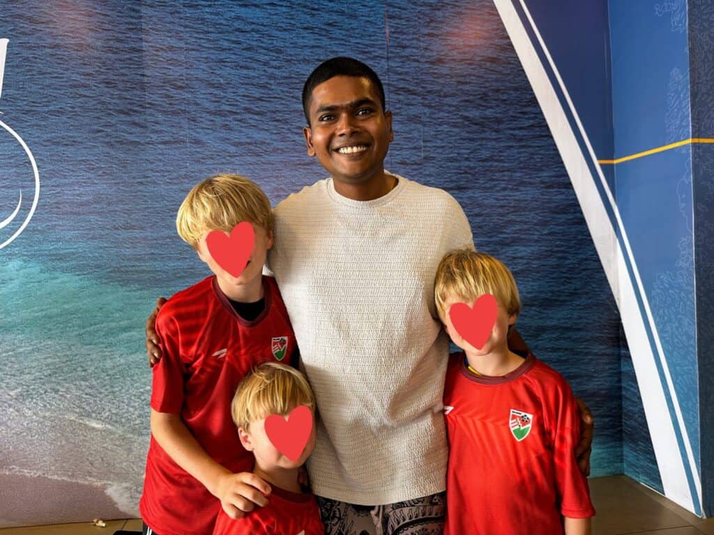 Maldives guide with three boys in red shirts.