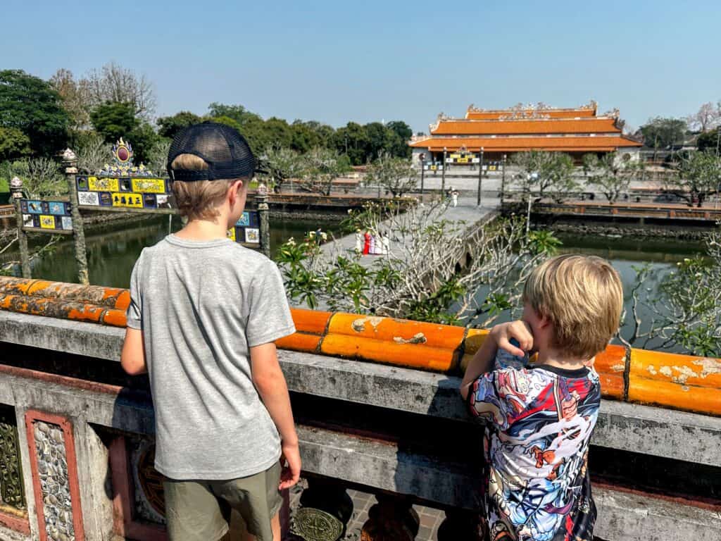 Boys look from balcony at Imperial City in Hue, Vietnam.