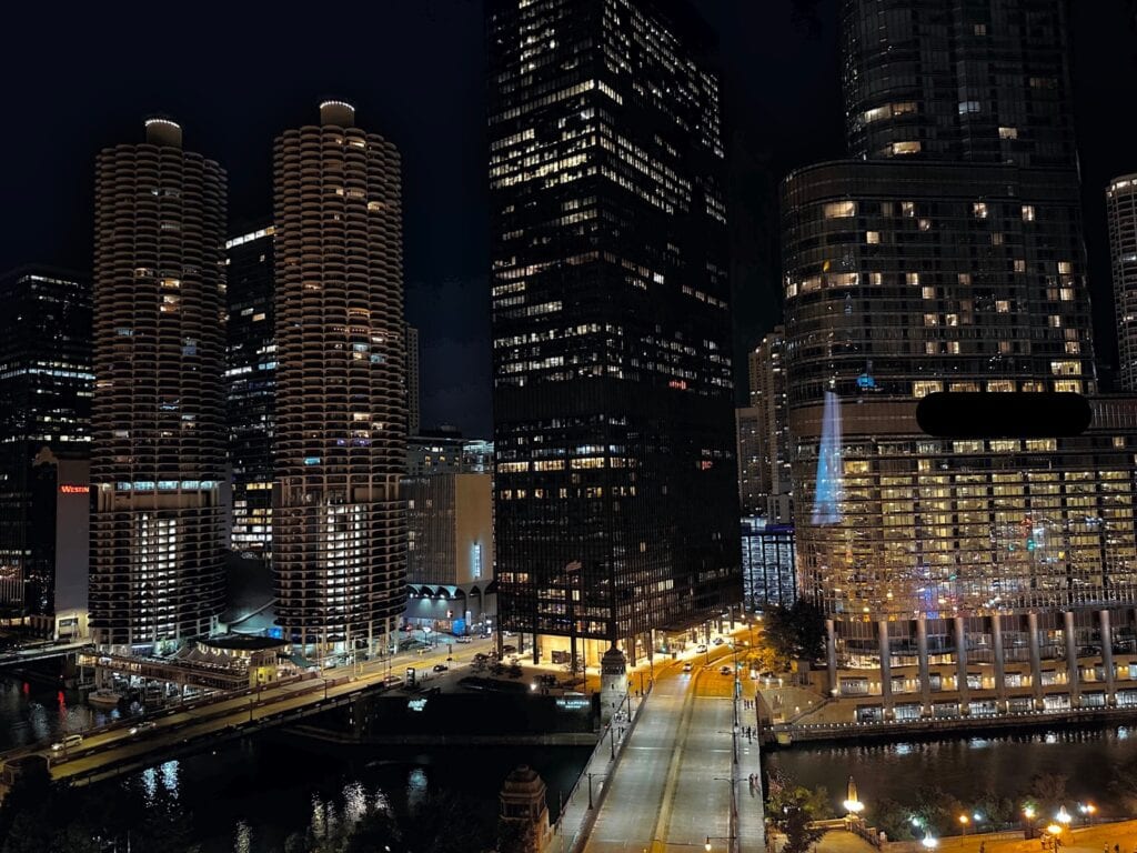 Skyscrapers fill the sky during the night in Chicago. Streets and river lit up.