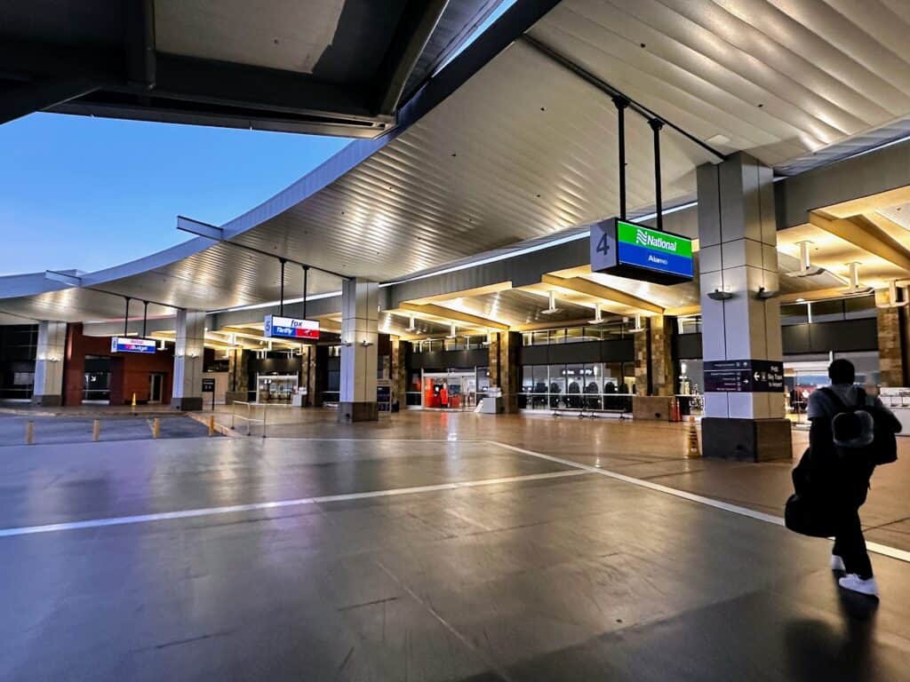 Man walks into the car rental center at the Phoenix airport at dusk.