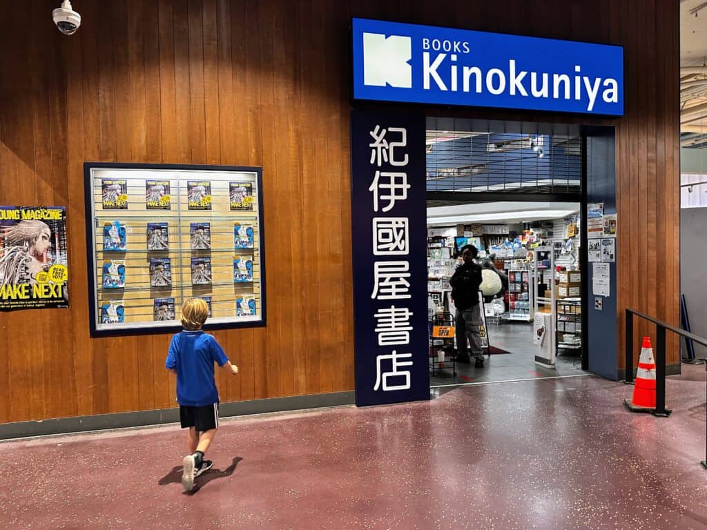 Boy in blue shirts enters Kinokinuya bookshop in Seattle.