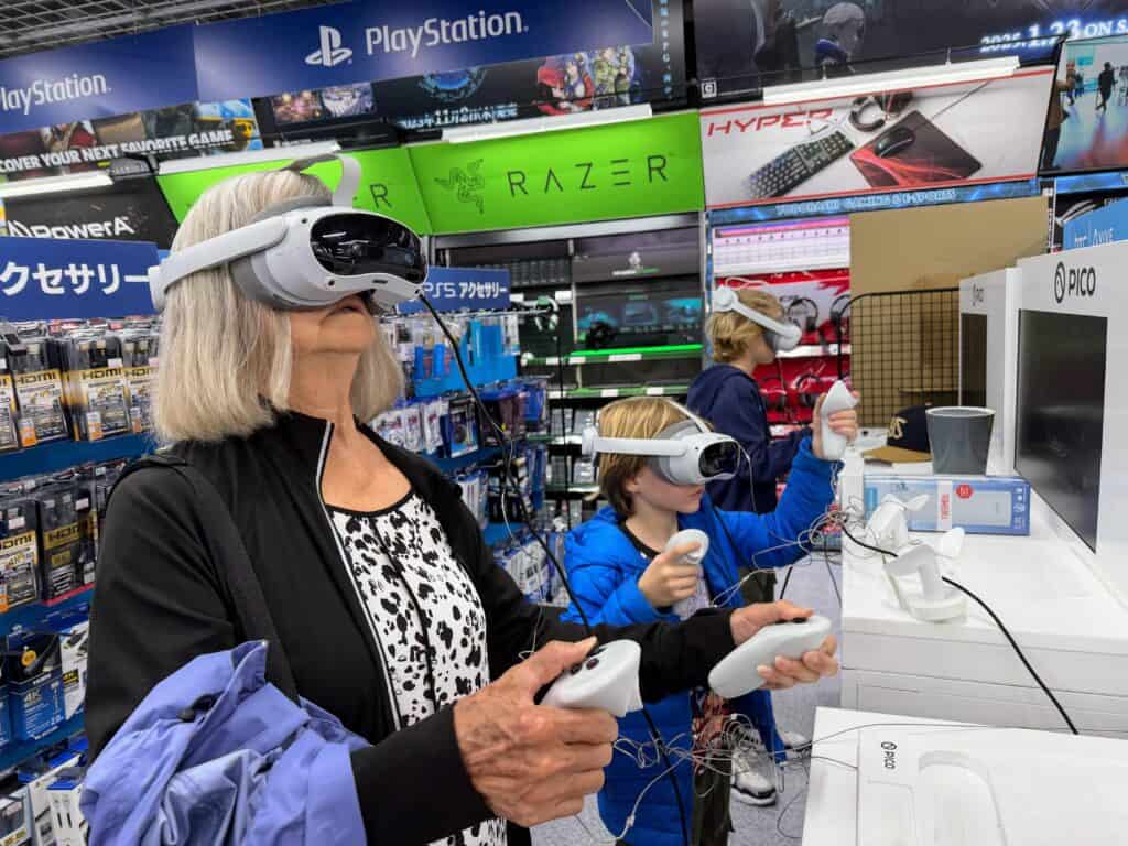 Woman and two boys play VR video games inside an electronics store in Tokyo, Japan.