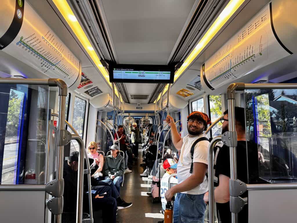 People sit and stand on the Link Light Rail in Seattle, Washington.