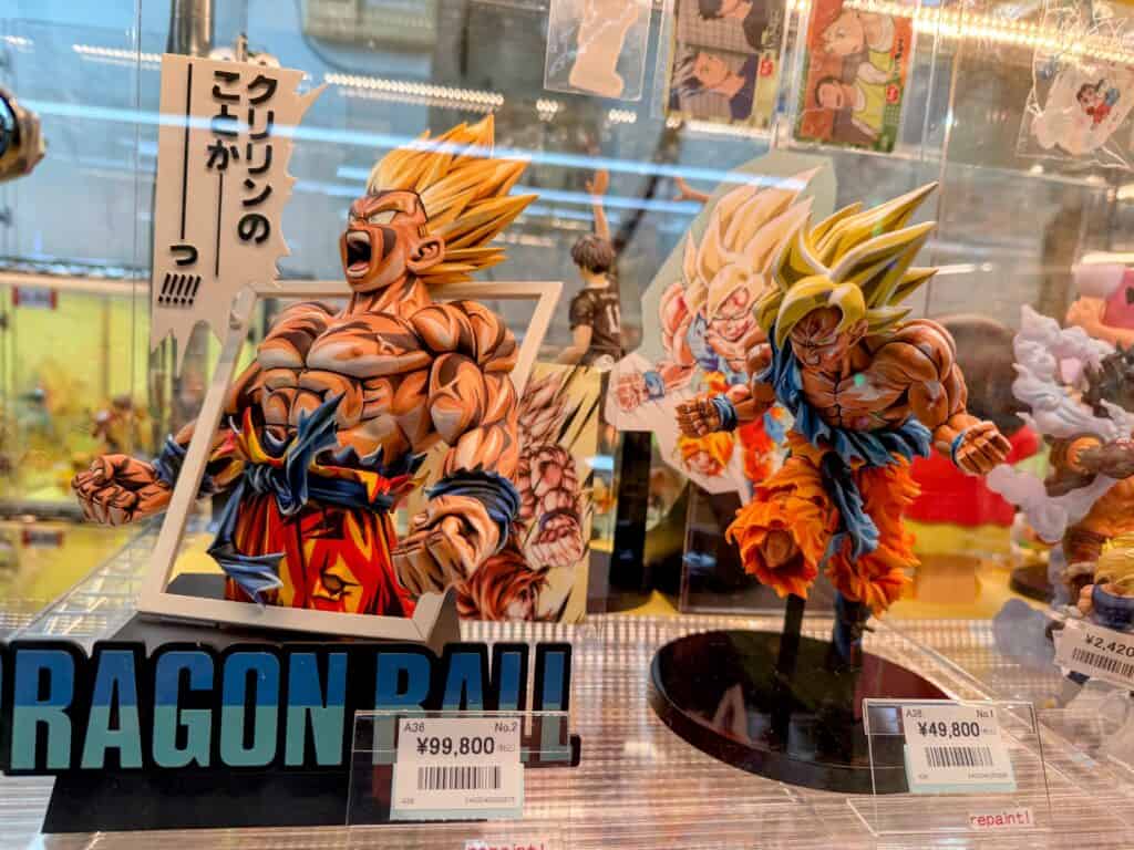 Colorful repainted anime figures on display in a glass case at a shop in Tokyo, Japan.