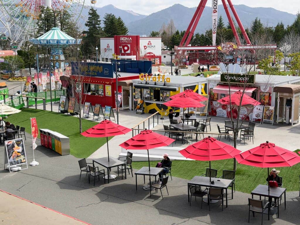 view from above of food area at Fuji-Q Highland theme park in Japan. Rides in background.