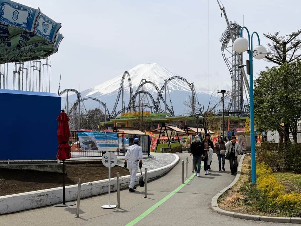 Rides at Fuji-Q Highland in Japan with snow-capped Mt. Fuji in the background.