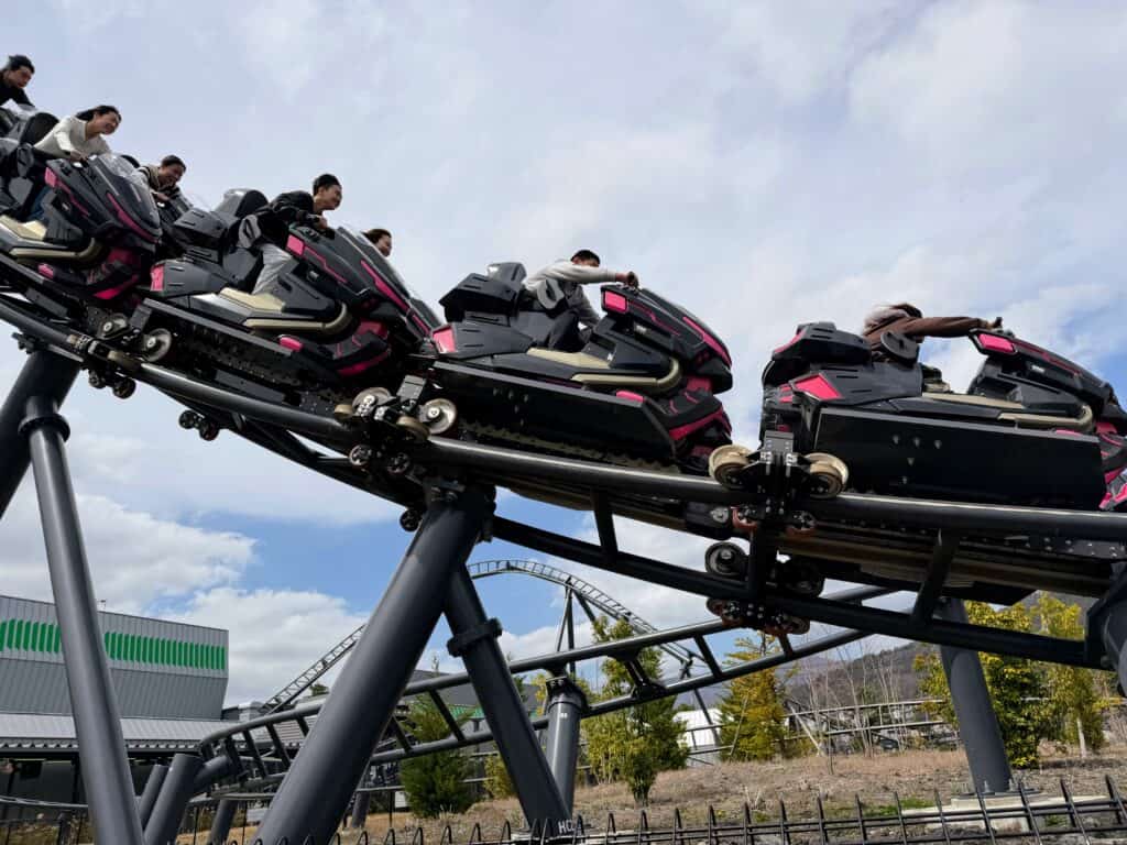 People on a motorcycle rollercoaster at Fuji-Q Highland theme park in Japan.